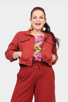 Dark red cropped jacket with button front, pointed collar, and flap chest pockets