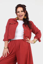 Dark red cropped jacket with button closure, stand collar, and flap pockets
