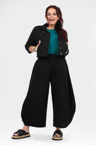 Black wide-leg pants with gathered elastic waist, ankle-length and loose fit
