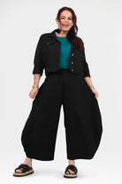 Black loose wide-leg pants with elastic waistband and relaxed drape, full front view