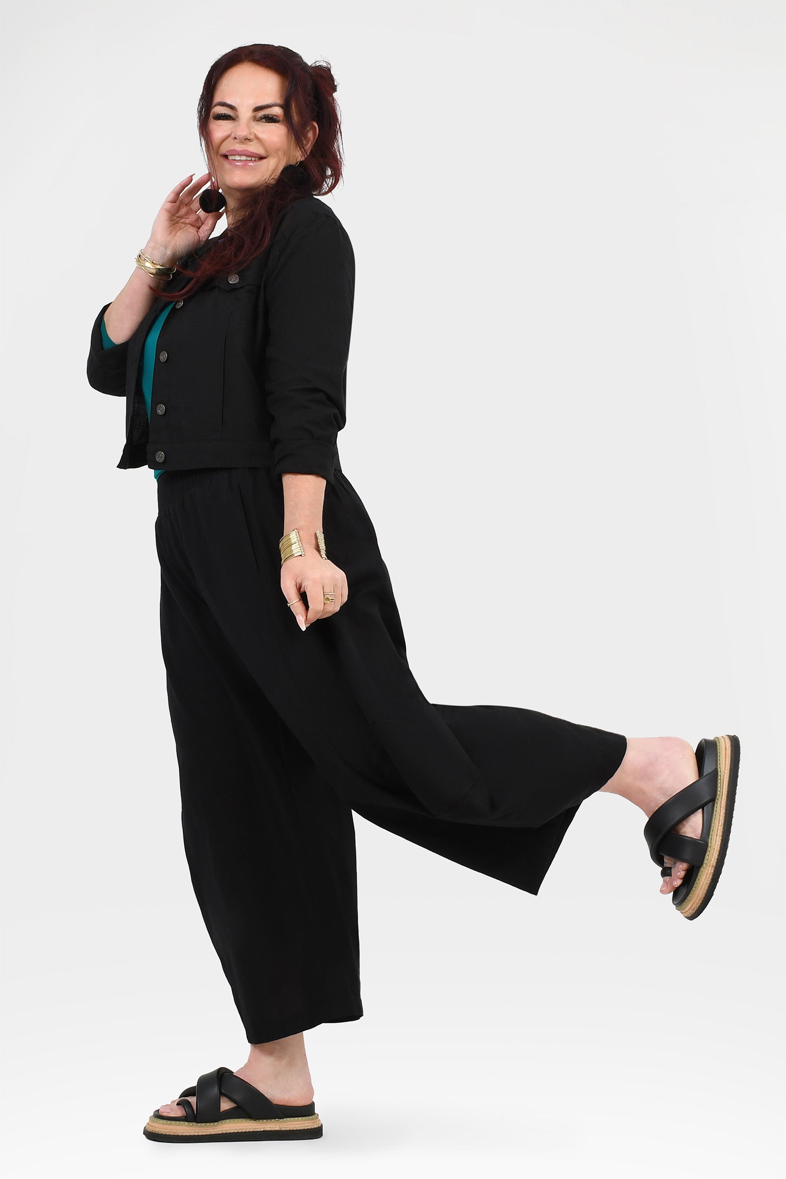 Black wide-leg pants with elastic waist, side view with tapered loose hem