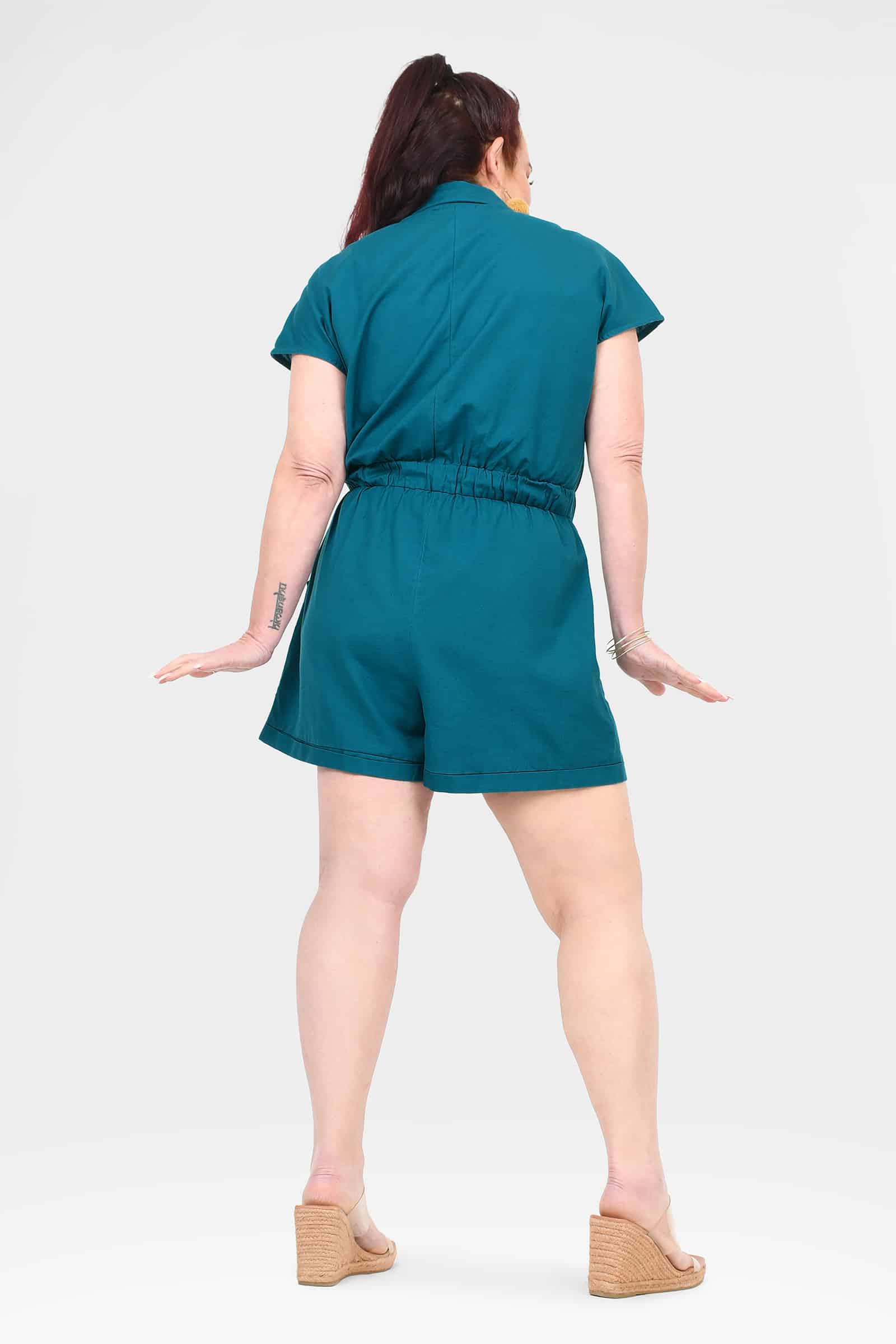 Dark teal belted romper with short sleeves, back view