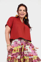 Dark red V-neck short-sleeve top with chest pocket and relaxed drape