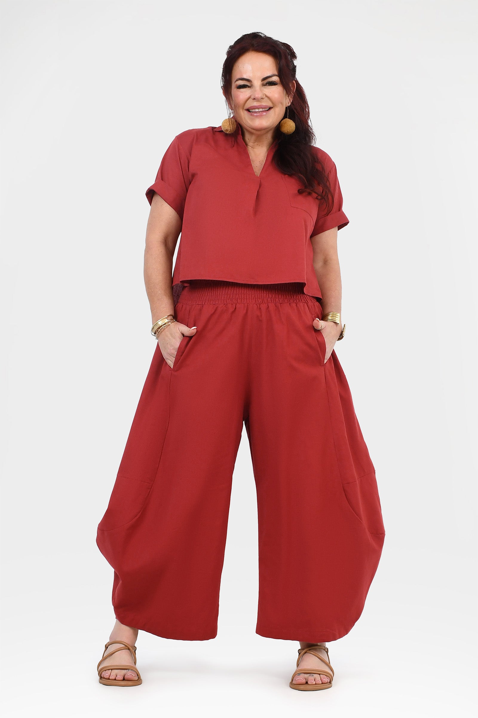 Wide-leg dark red pants with elastic waistband and relaxed, full-length legs.