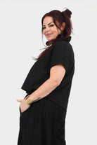 Black V-neck short-sleeve top, side view with loose drape