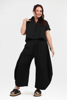 Black wide-leg pants with gathered elastic waist, front view with loose leg opening
