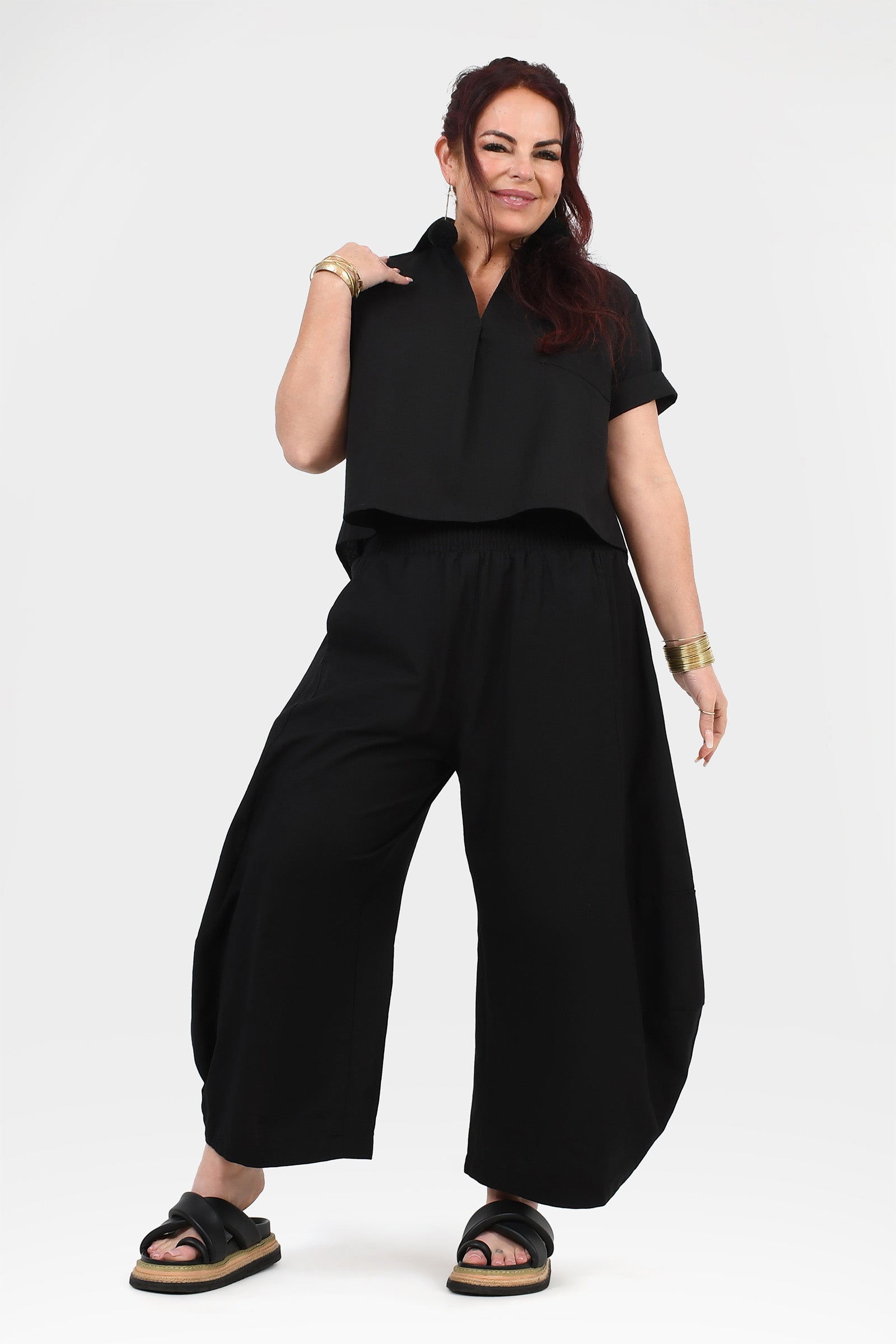 Black wide-leg pants with gathered elastic waist, front view with loose leg opening