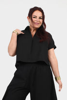 Black V-neck short-sleeve top with relaxed fit and curved hemline