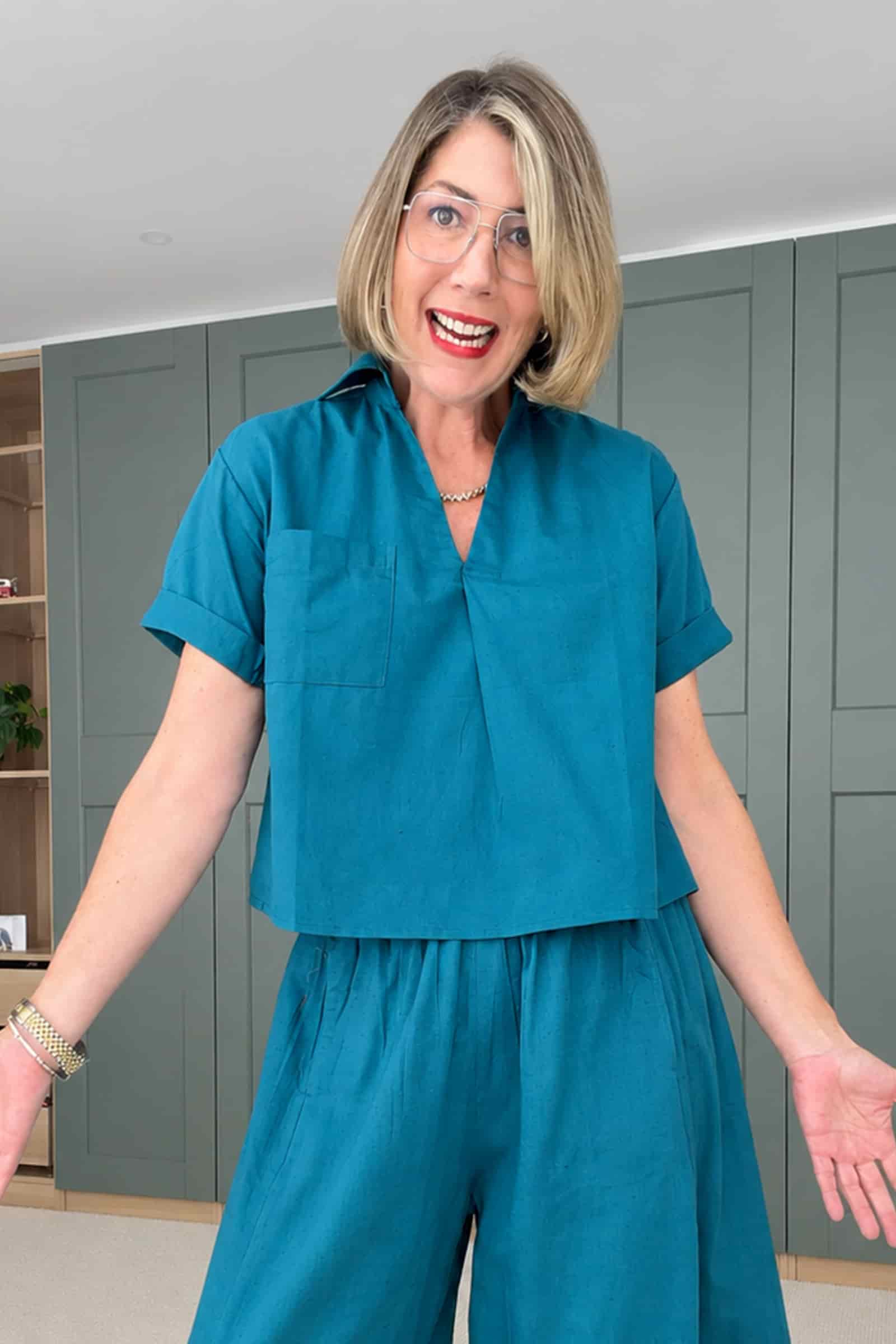 Dark teal V-neck top with short sleeves, relaxed fit and button-less placket