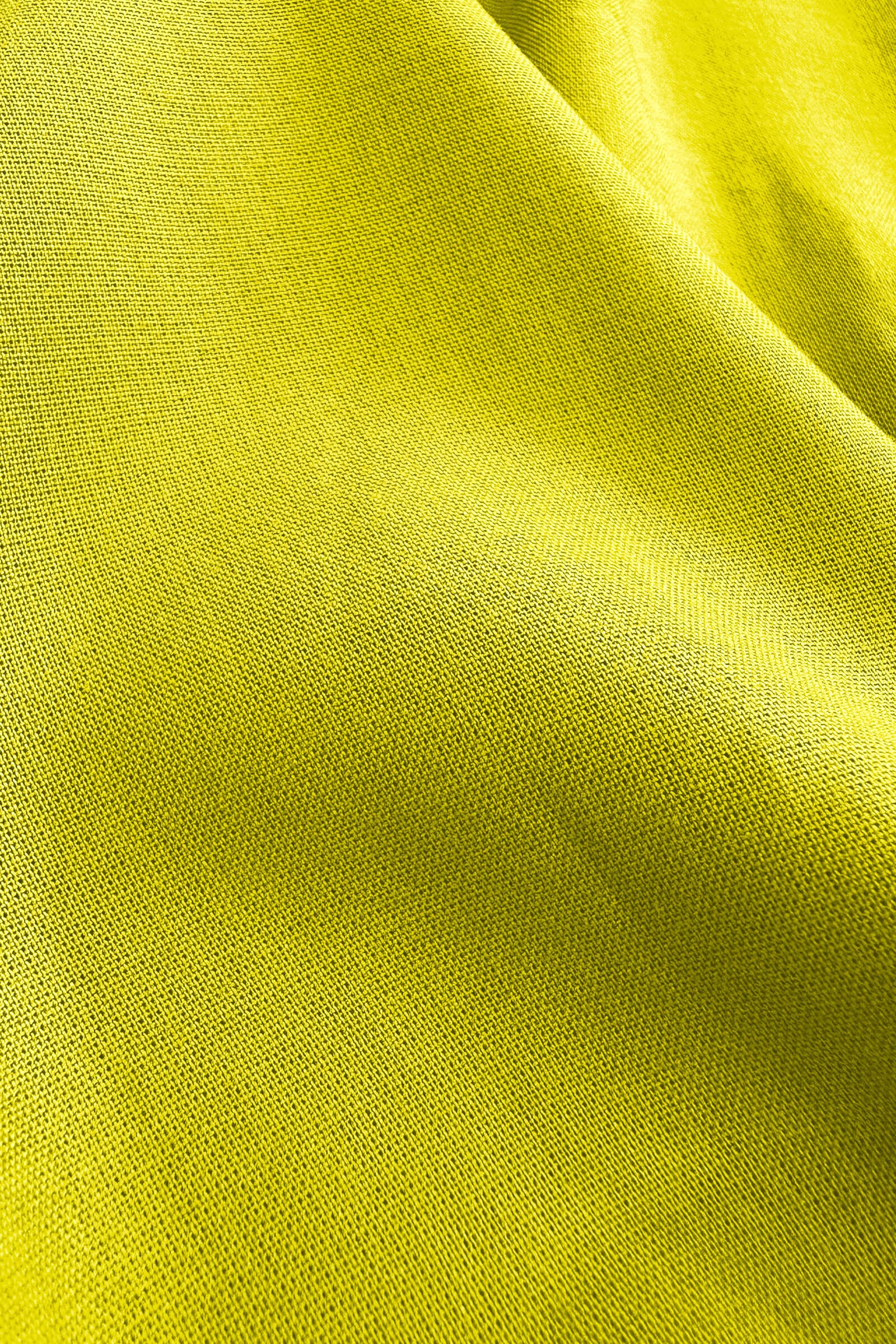 Lime green woven pants fabric close-up with fine textured weave