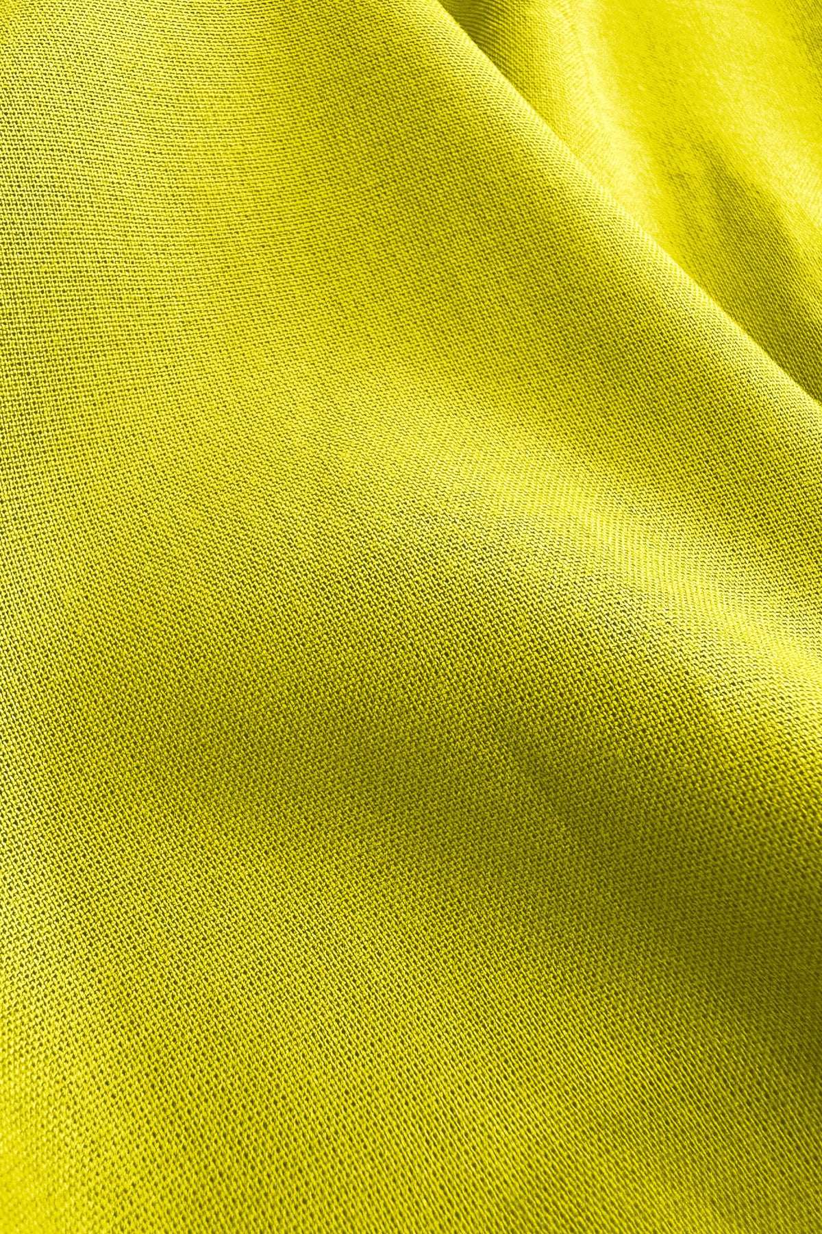 Lime green woven pants fabric close-up with fine textured weave