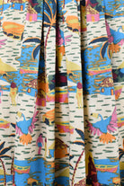 Close-up of printed skirt fabric with cream base and colorful animal motifs
