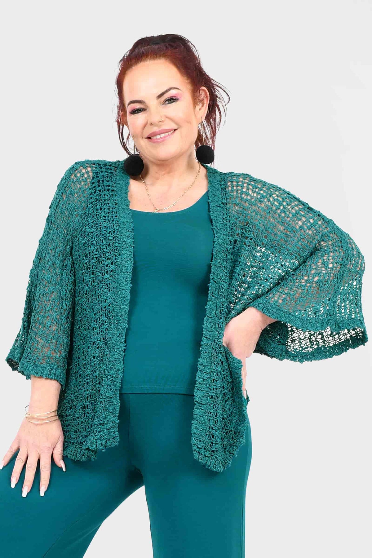 Teal popcorn-knit jacket with open front, wide sleeves, and fringe-like texture