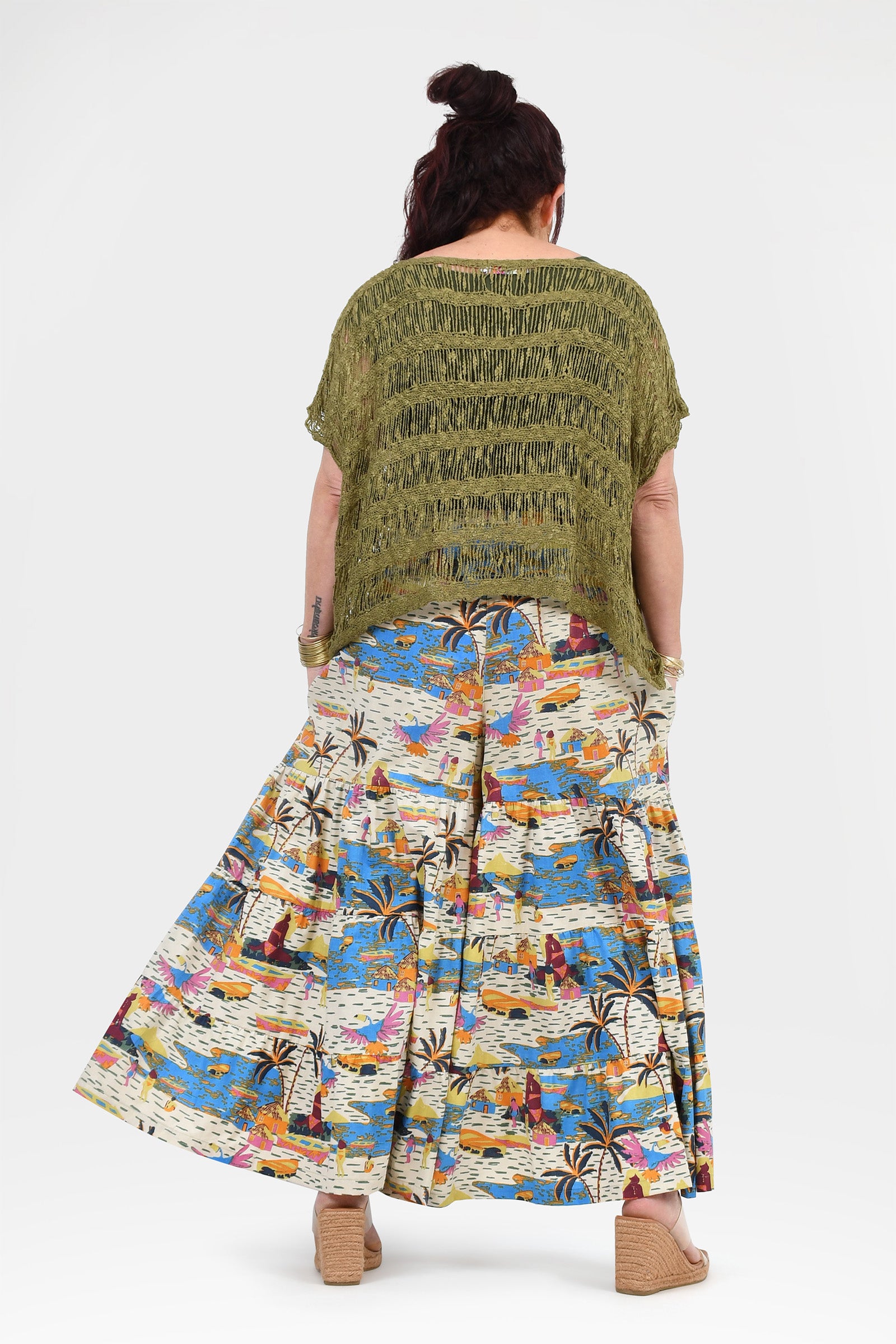 Back view of printed wide-leg pants; white with blue-orange tropical design and elastic waist