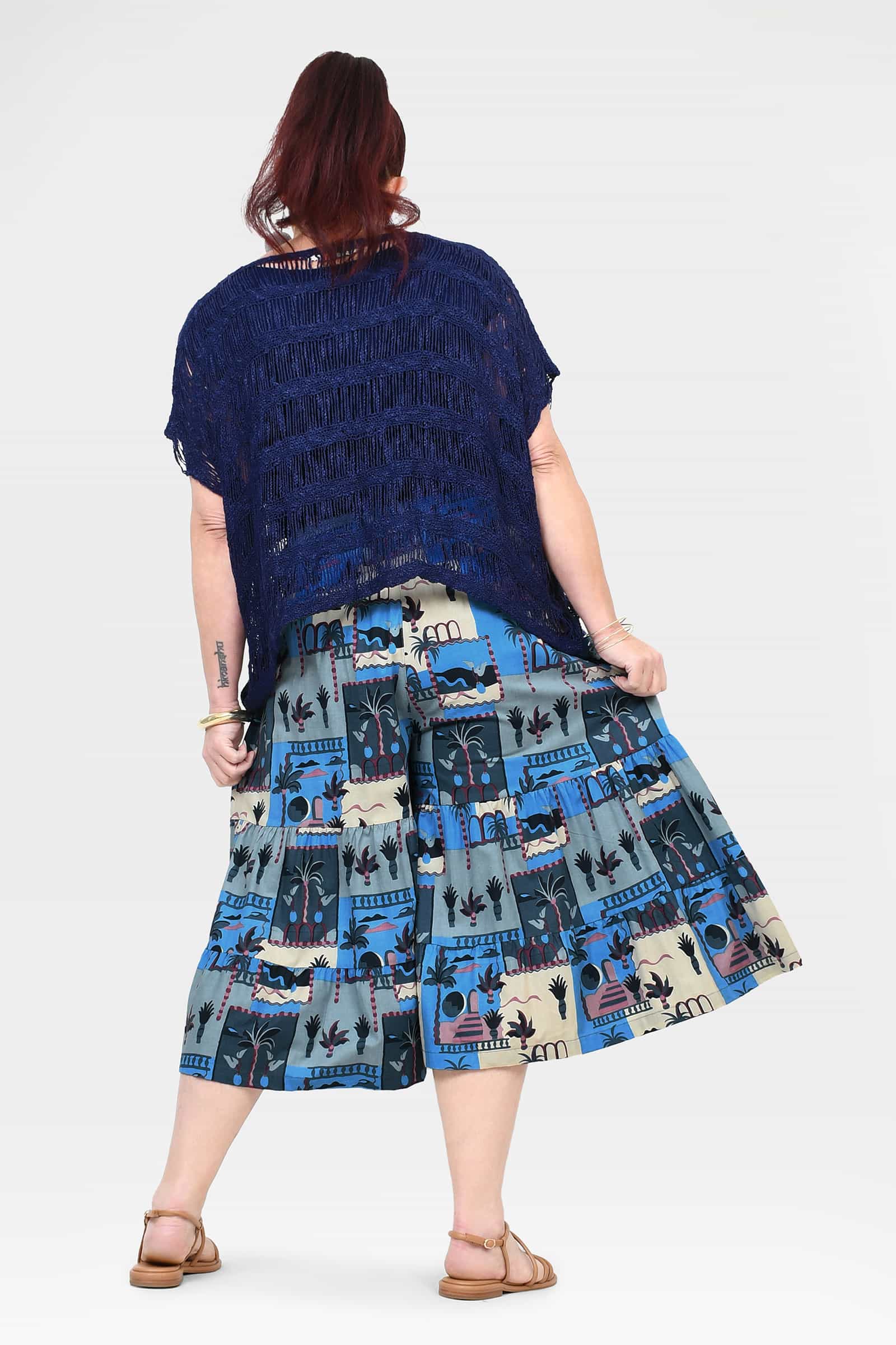 Back view of navy and blue printed 3/4 pants with tiered, skirt-like hem