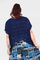 Back view of dark navy popcorn knit top with frayed short sleeves and tiered print hem