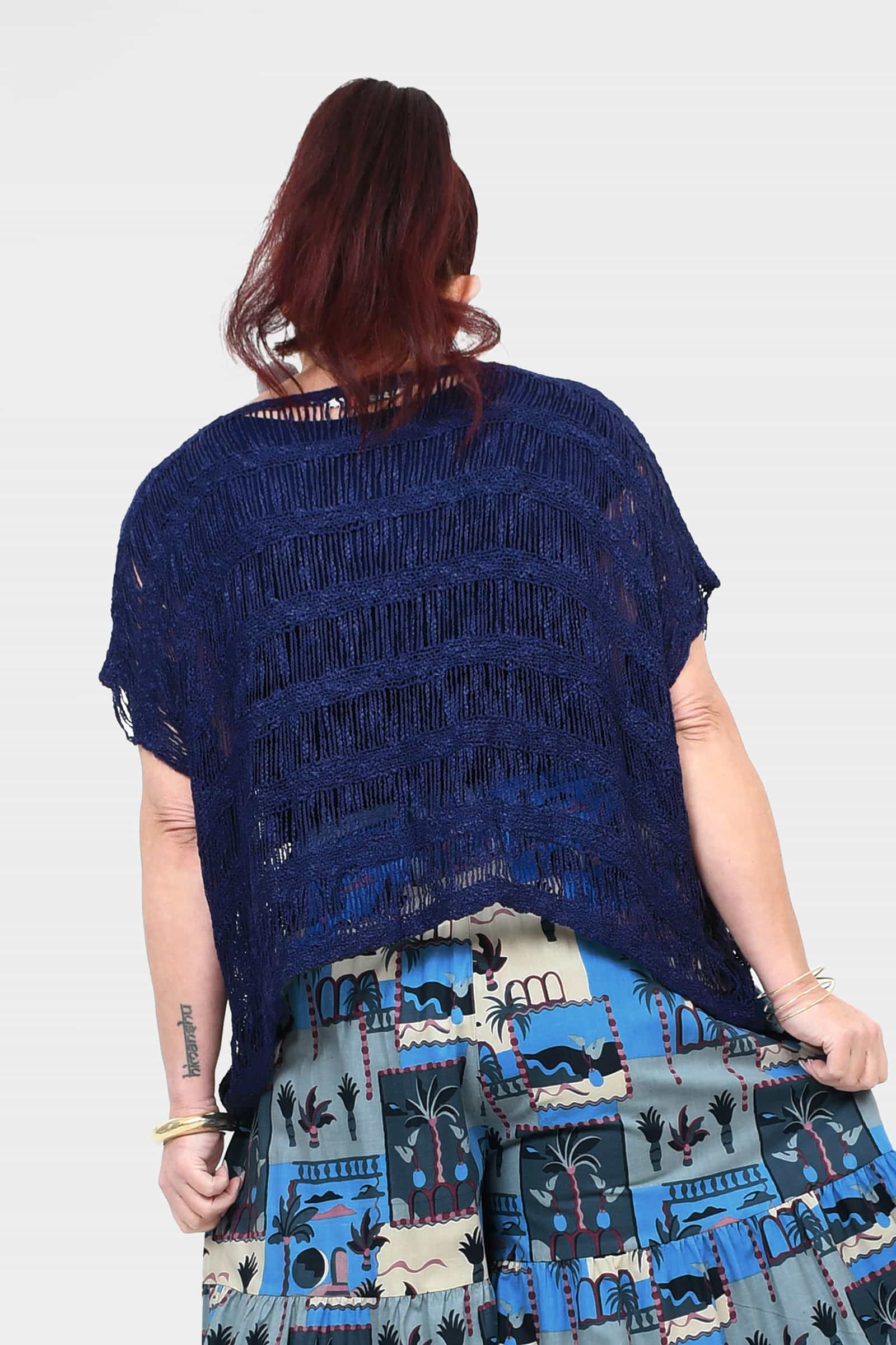 Back view of dark navy popcorn knit top with frayed short sleeves and tiered print hem