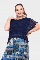Dark navy popcorn knit top with frayed neckline and blue/white tiered village print hem
