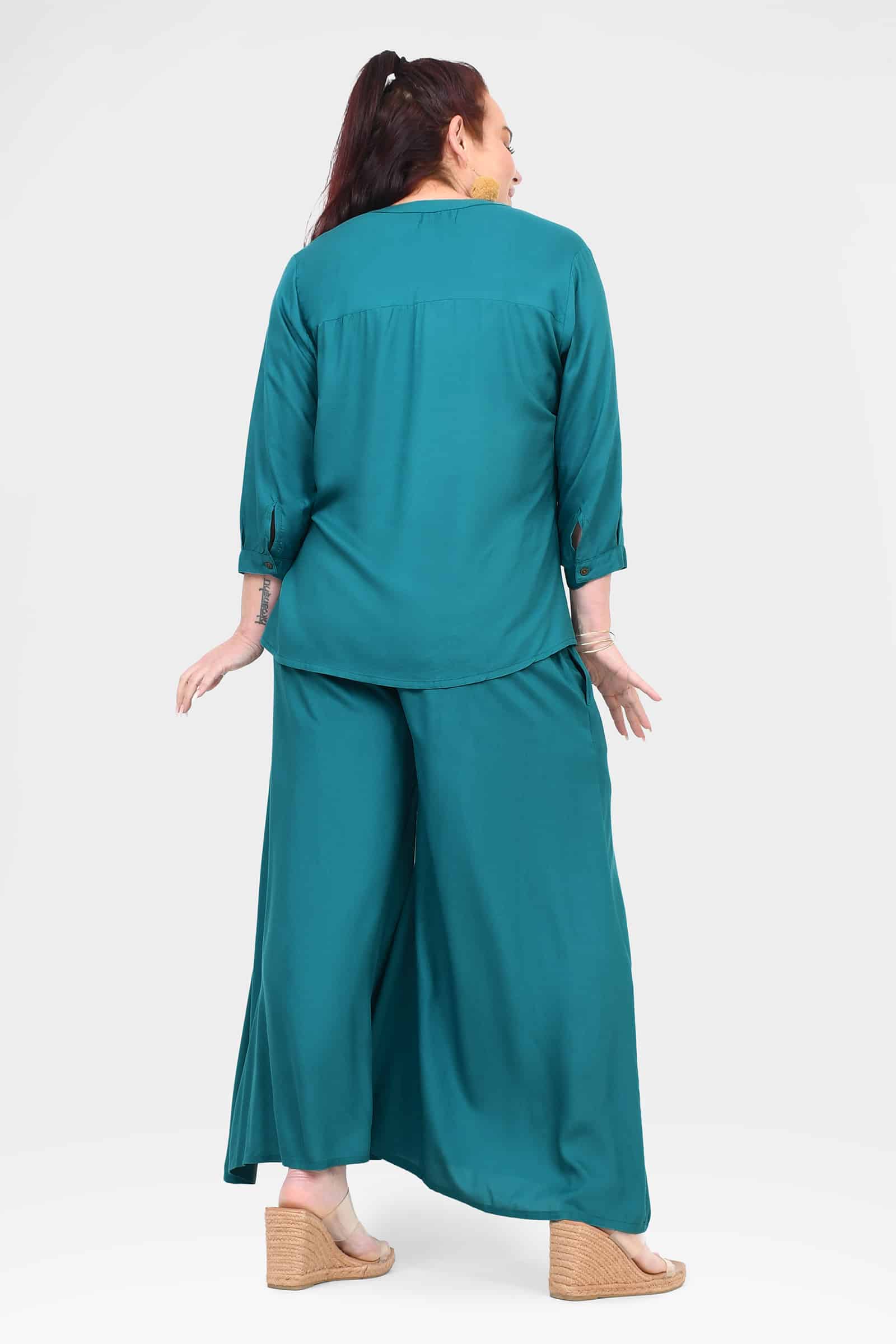 Teal wide-leg pants from back view, relaxed fit with smooth, flowing fabric