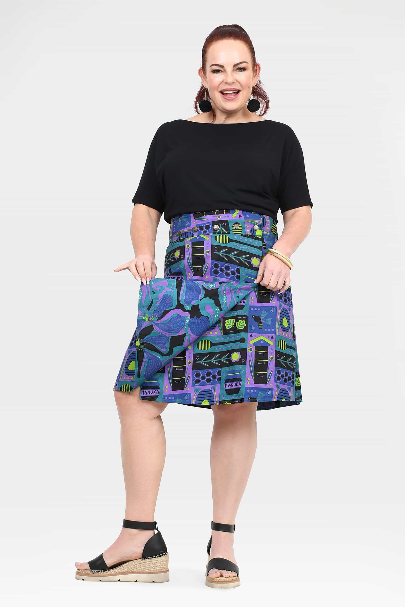 Reversible button skirt, black upper and teal-purple abstract print, side pocket flaps