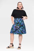 Reversible button skirt with black top and bold teal-purple print, side pocket flaps