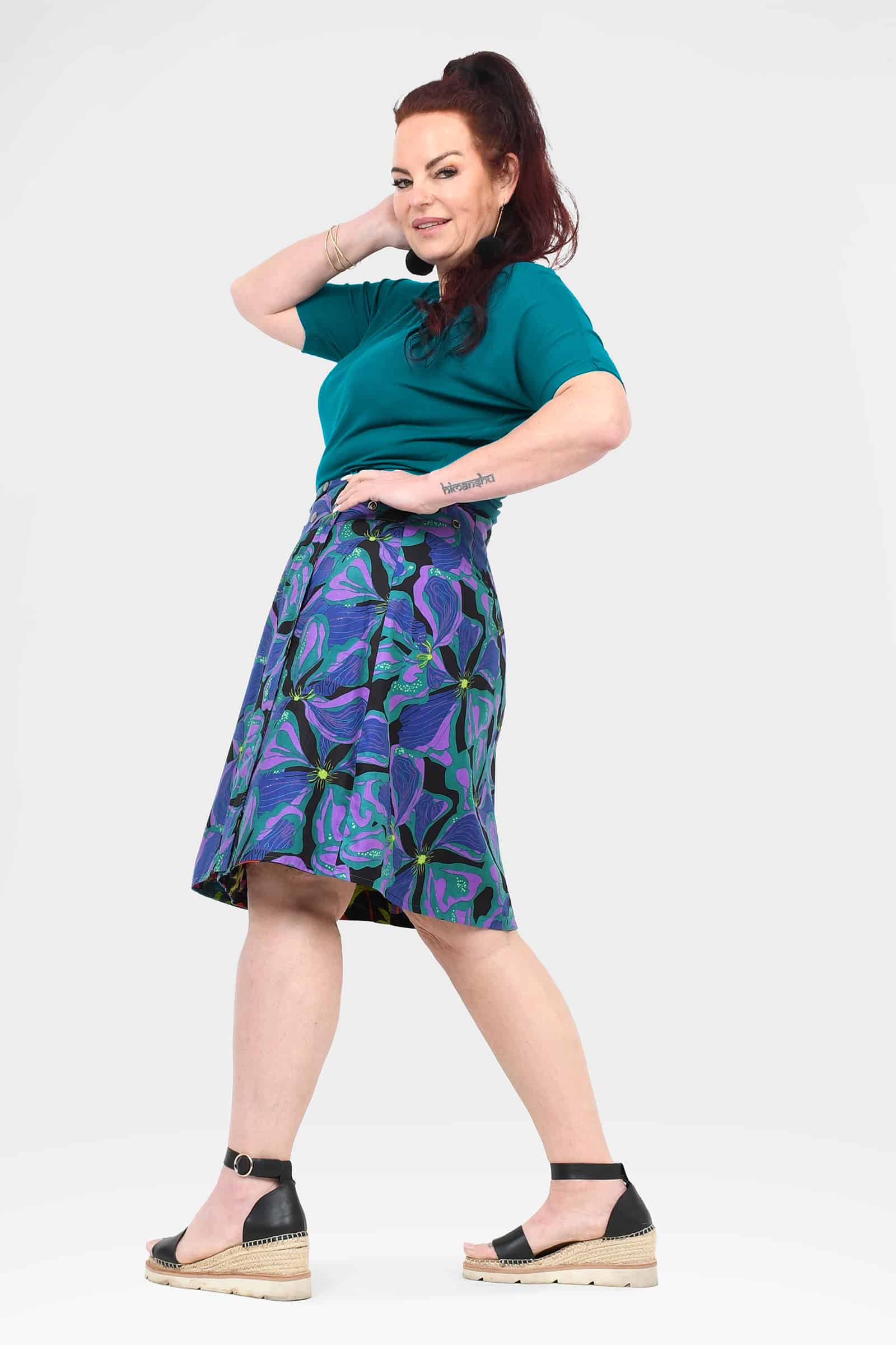 Long reversible button skirt in purple and teal tropical print, side view