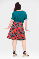 Back view: above-knee A-line skirt with teal waist panel and multicolor floral print