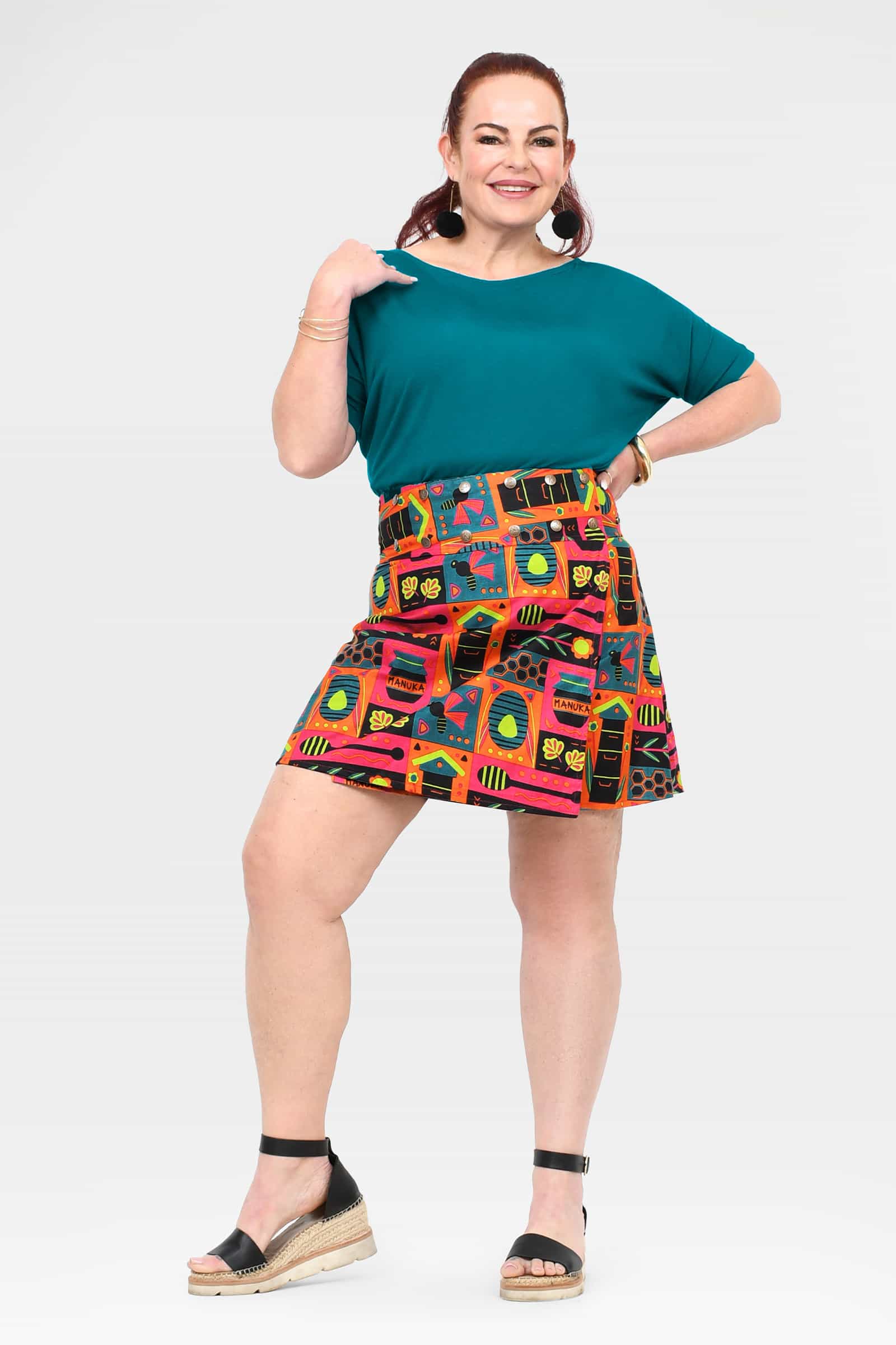 Short skirt with teal waistband panel and vibrant multi-color graphic print