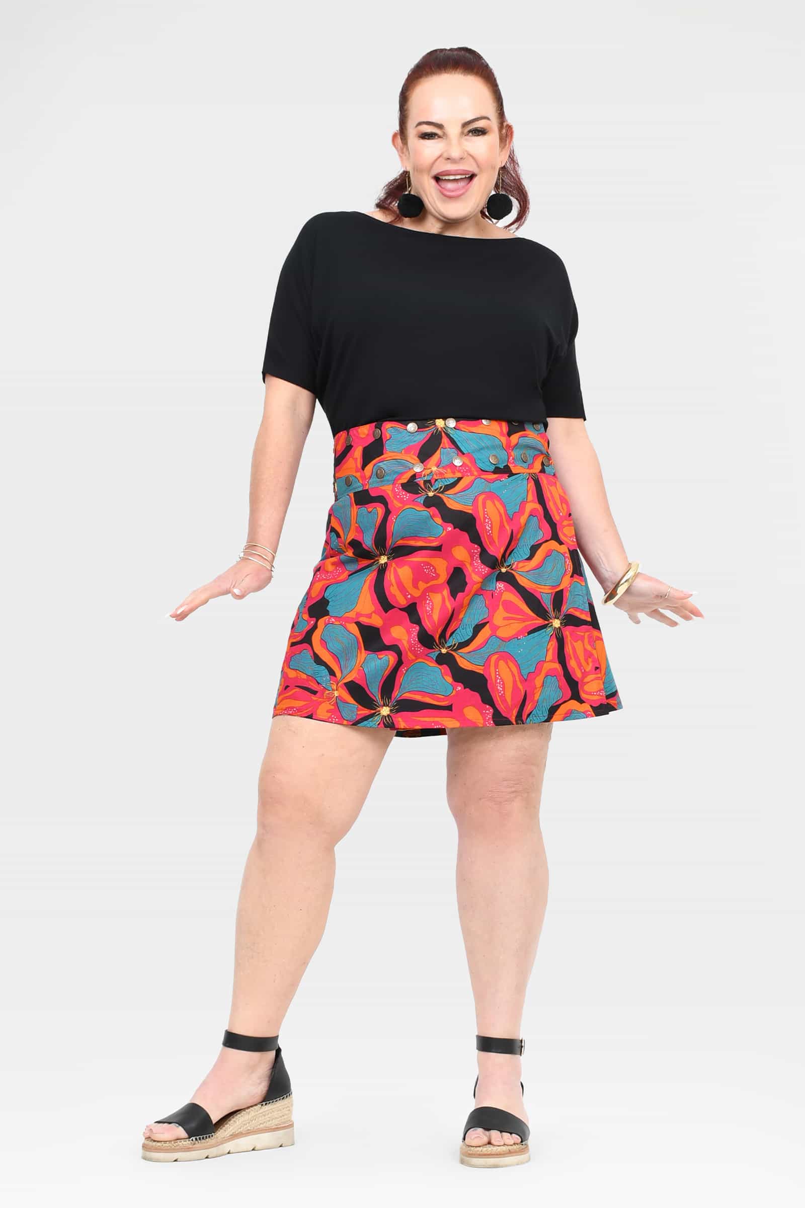 Short skirt with black waistband and bright tropical print, above-knee length