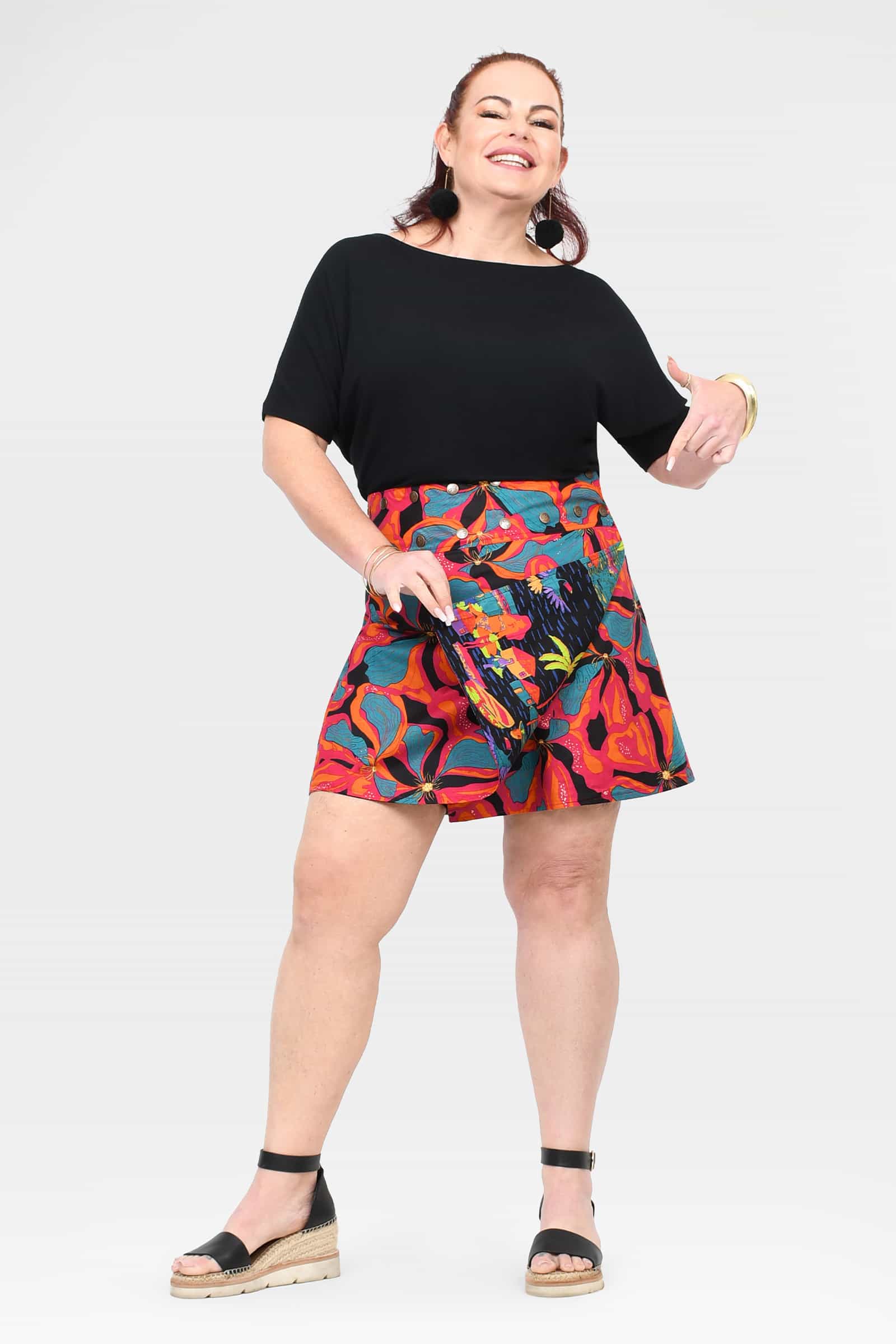 Short A-line skirt with black waistband and bright tropical print, above-knee length