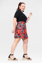 Above-knee A-line short skirt with black waistband and bright tropical print, side view