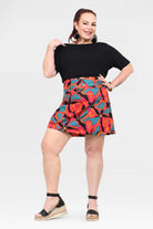 Above-knee A-line short skirt with black waistband and colorful tropical floral print, front view