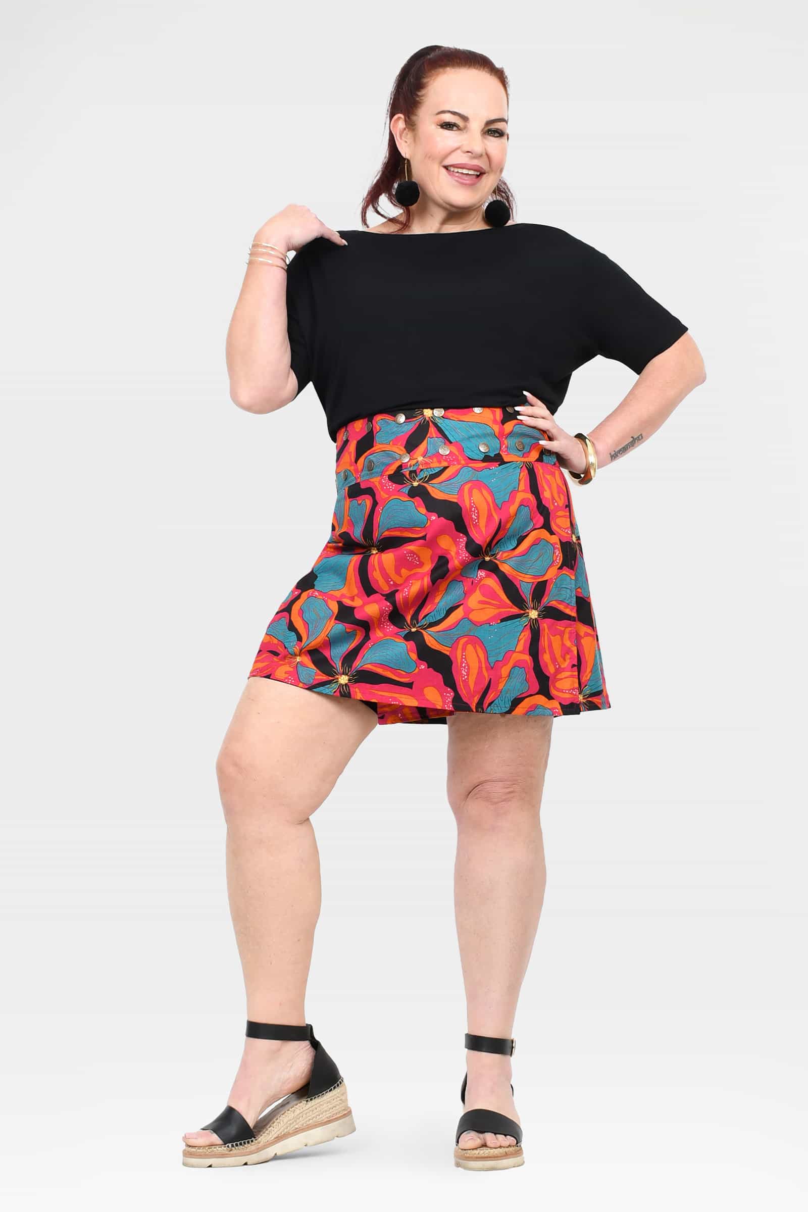 Above-knee A-line short skirt with black waistband and colorful tropical floral print, front view