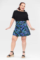 Reversible short button skirt, purple and teal floral print front with black reverse panel