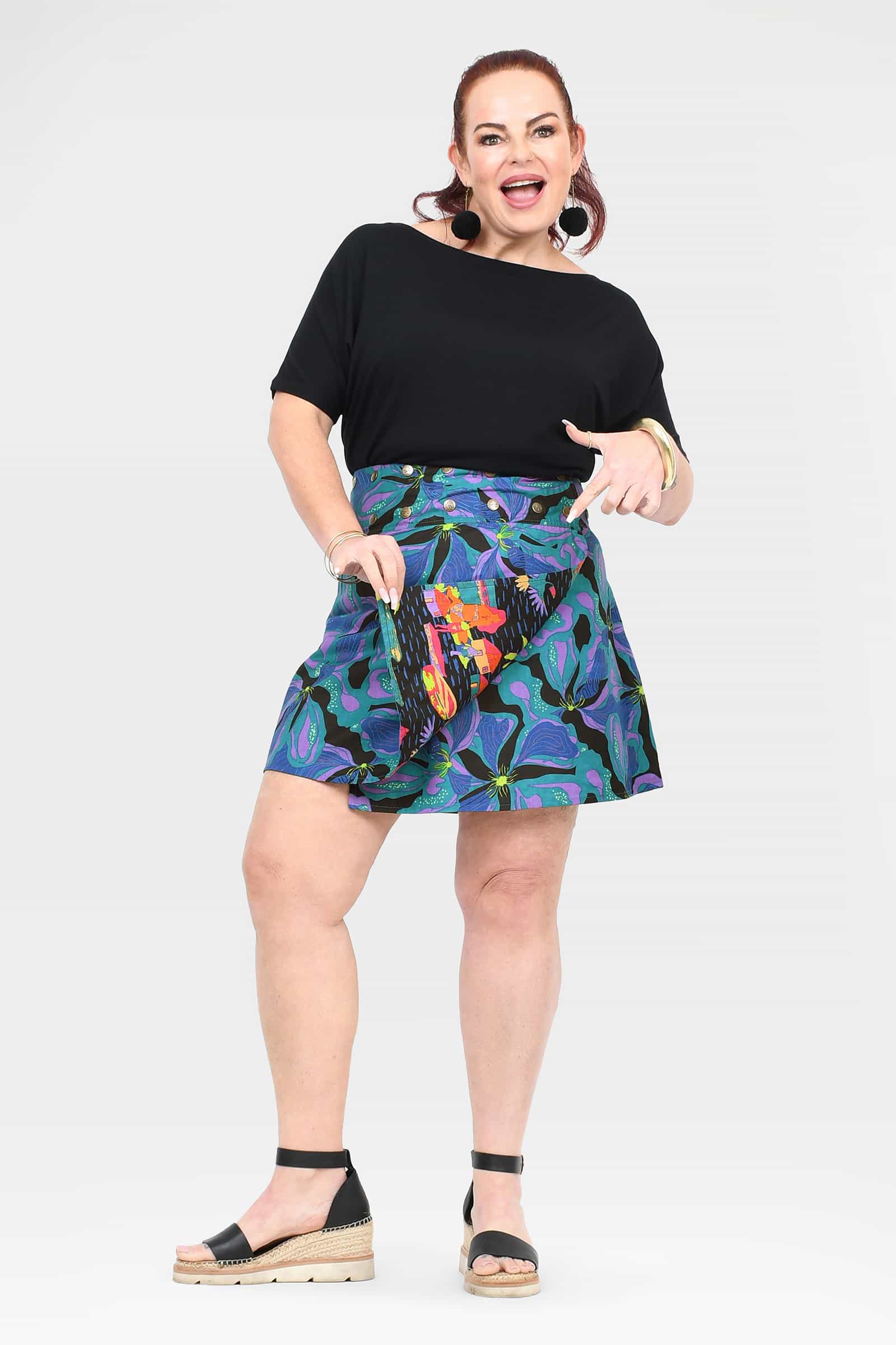 Reversible short button skirt, teal floral print with orange accents and black reverse