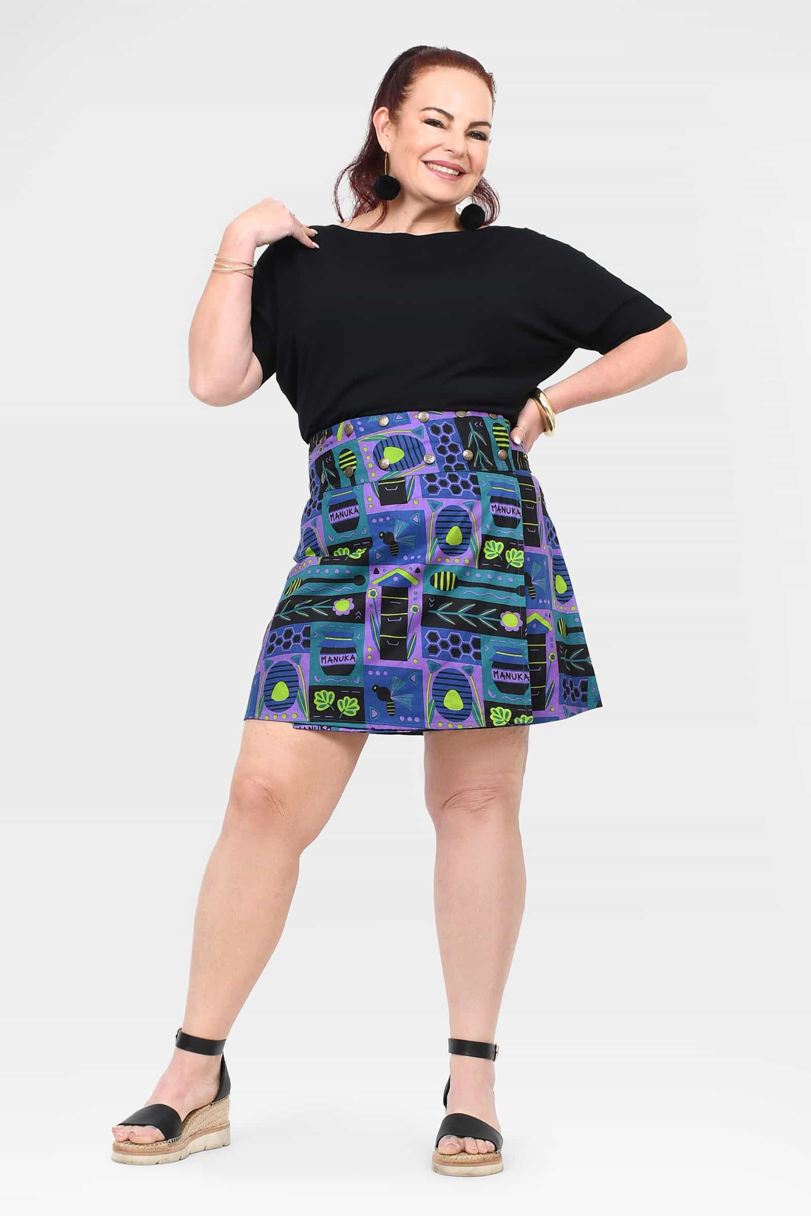 Reversible button short skirt with teal and blue purple graphic print, pleated panels.