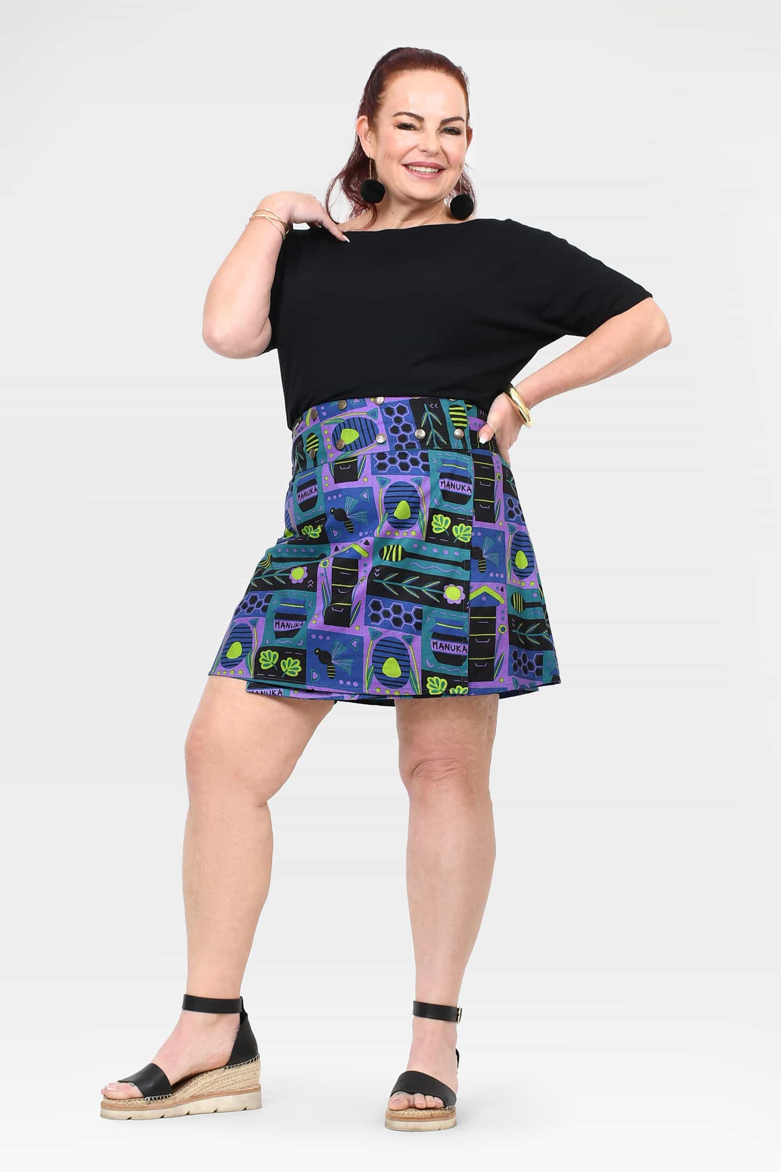 A-line reversible button short skirt with teal base and blue purple graphic print, pleats.