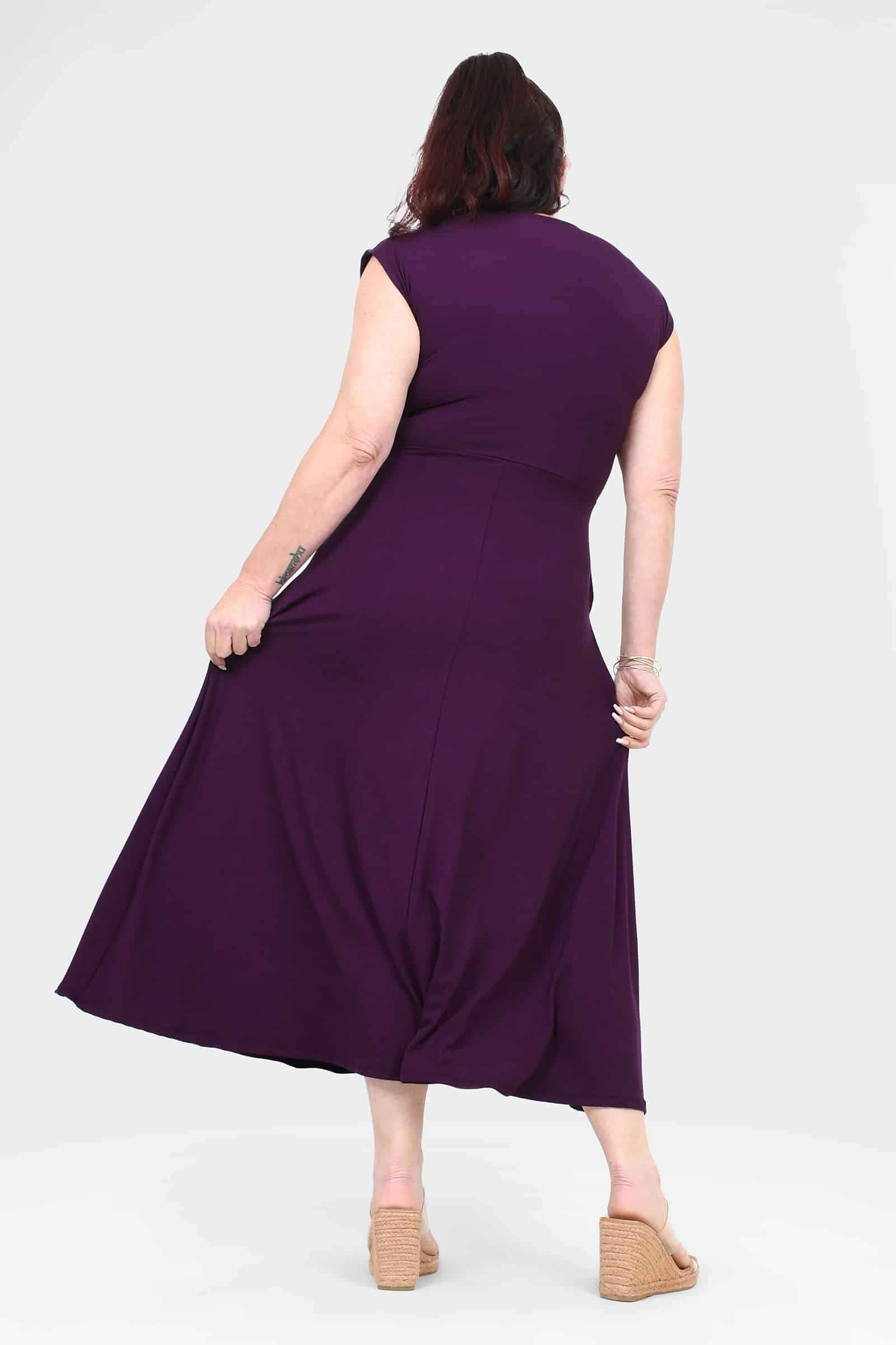 Back view of aubergine sleeveless dress with waist tie and flared skirt