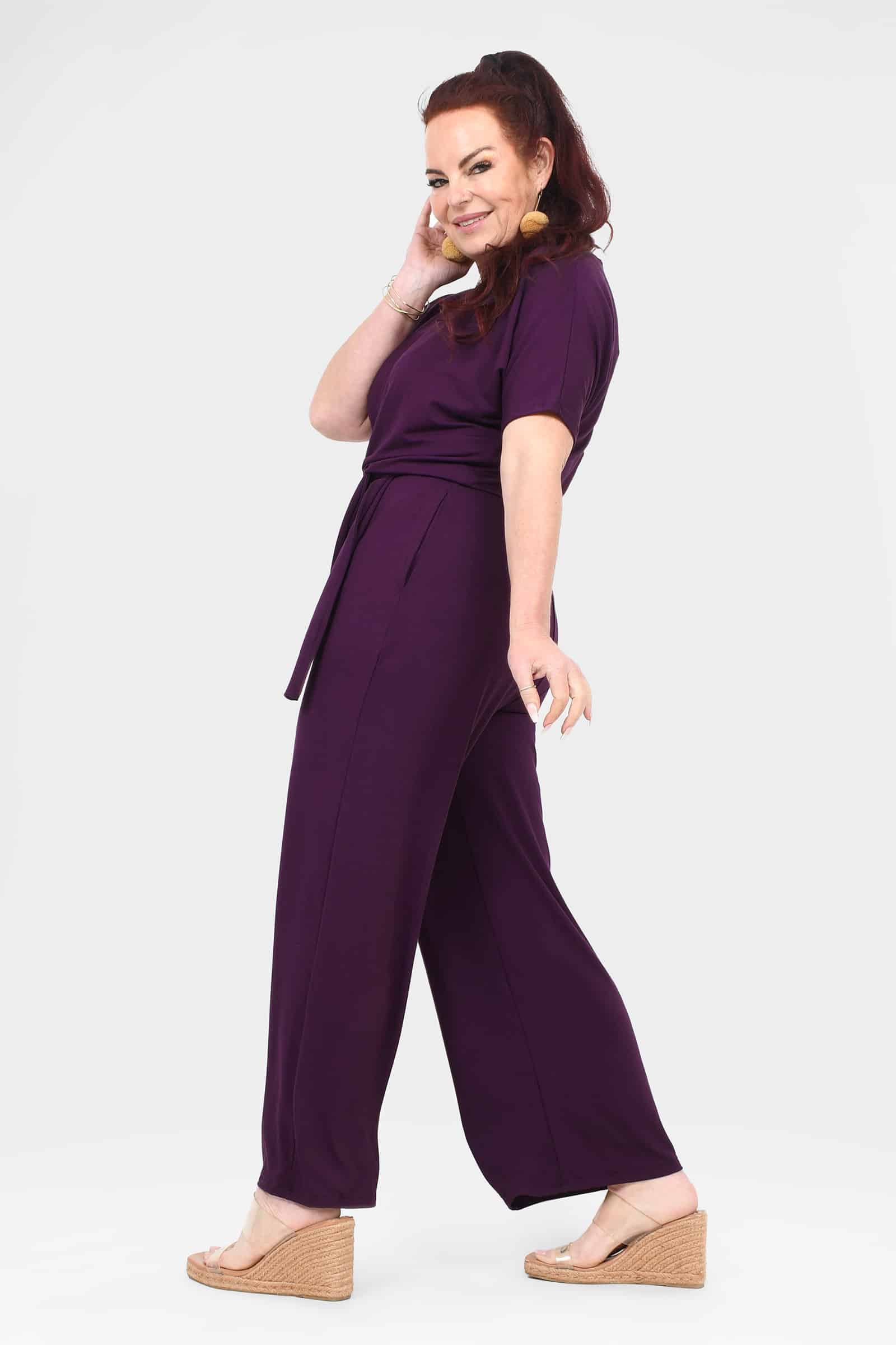 Women's aubergine jumpsuit, side view, short sleeves, tie-waist belt, wide legs