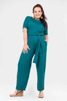 Dark teal tie-waist jumpsuit with short sleeves and wide-leg pants