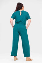 Dark teal jumpsuit with open back, tie waist, short sleeves, and wide legs