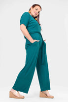 Dark teal tie-waist wide-leg jumpsuit with short sleeves and flowing legs