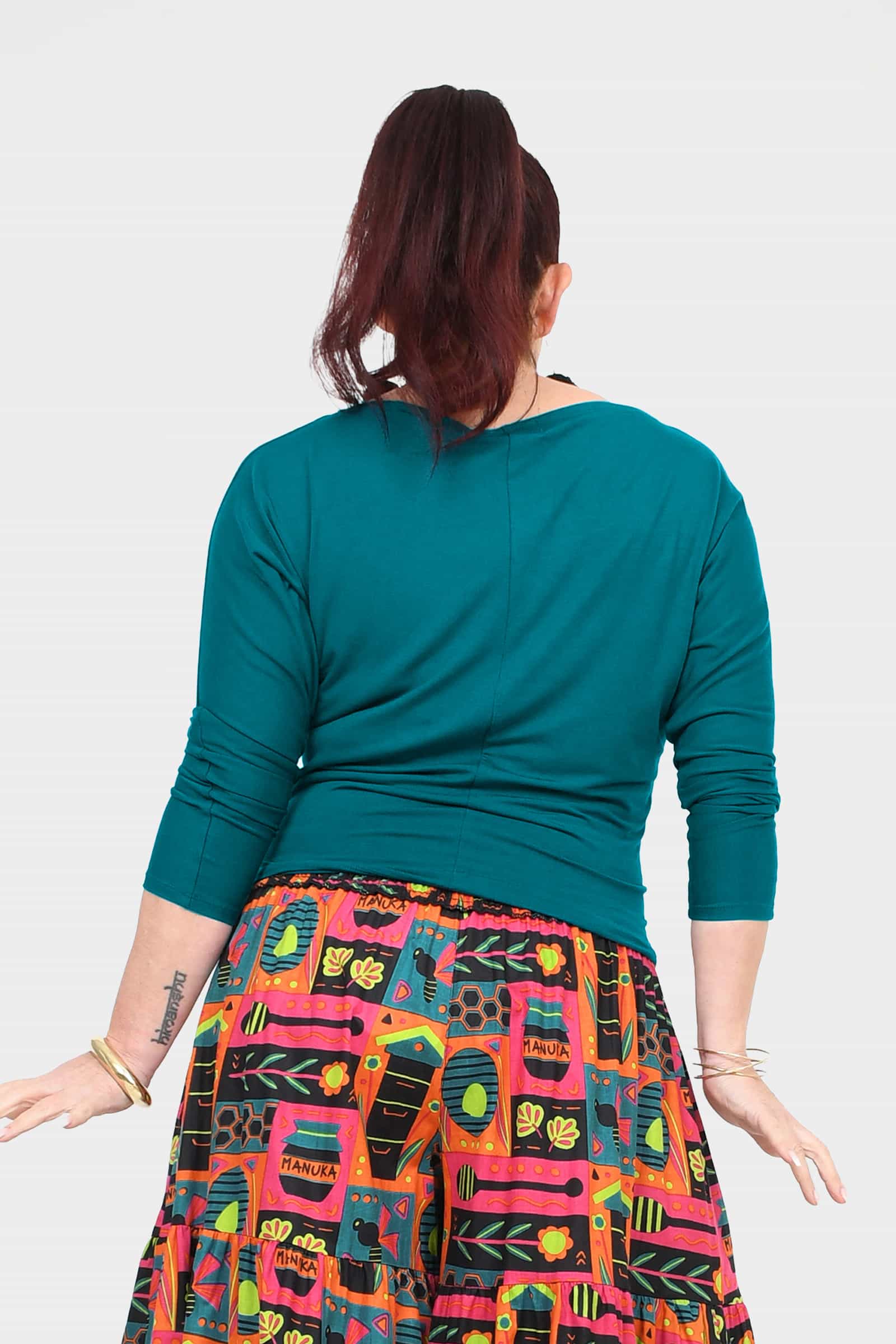 Dark teal crew-neck top with three-quarter sleeves and straight back seam