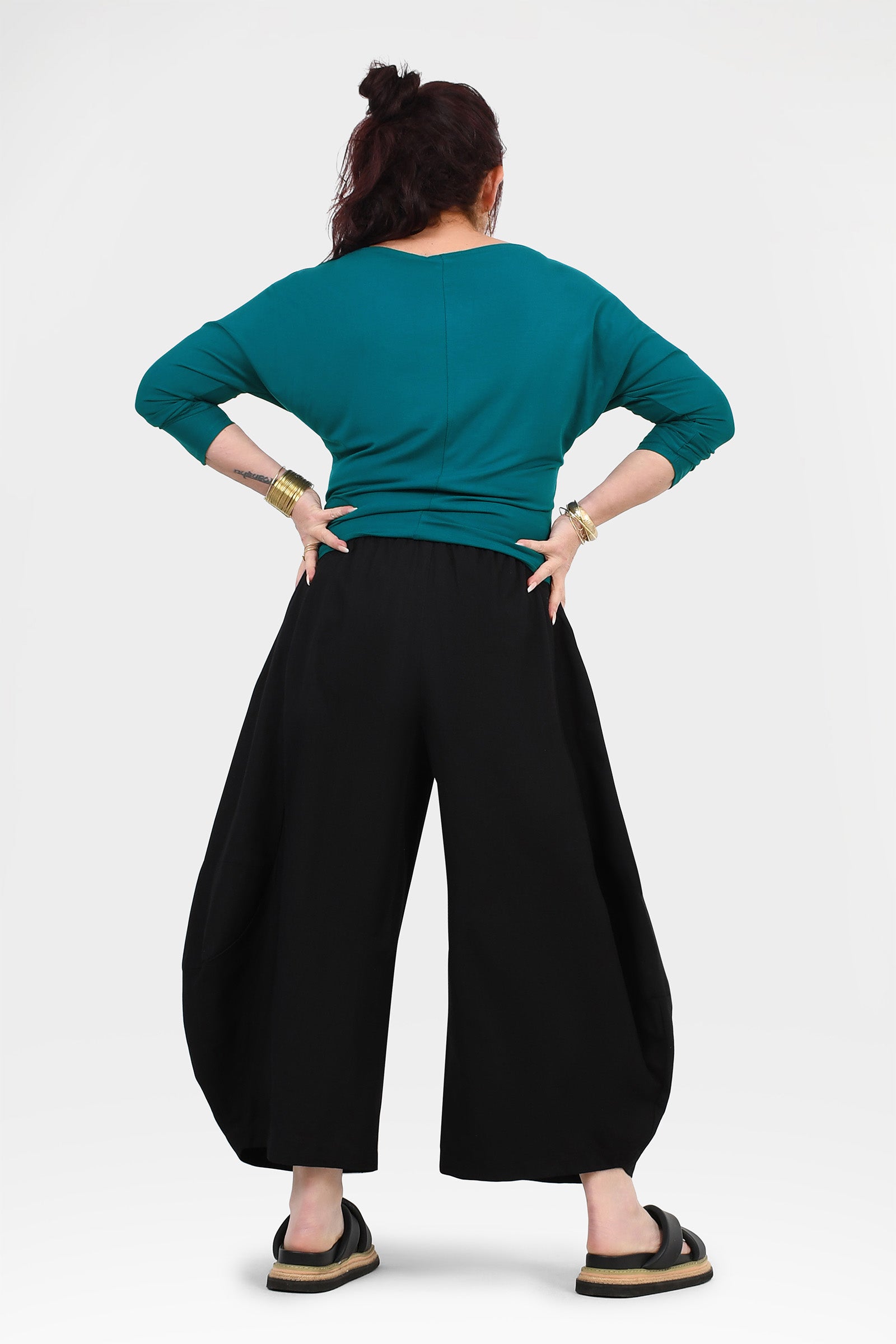 Black wide-leg pants with gathered waist, back view with flowing wide legs