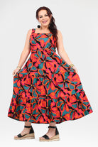 Flowing sleeveless maxi dress with tiered skirt and abstract floral print, colorful poppy pink teal