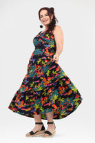Sleeveless tropical maxi dress with bold multicolor pattern and full skater-style skirt