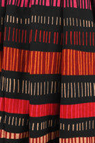Close-up of a fabric with red, black, and orange striped pattern