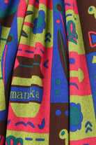 Colorful fabric with abstract patterns and 'manka' branding.