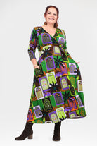 Woman wearing a colorful dress with a pattern of haunted houses on a white background