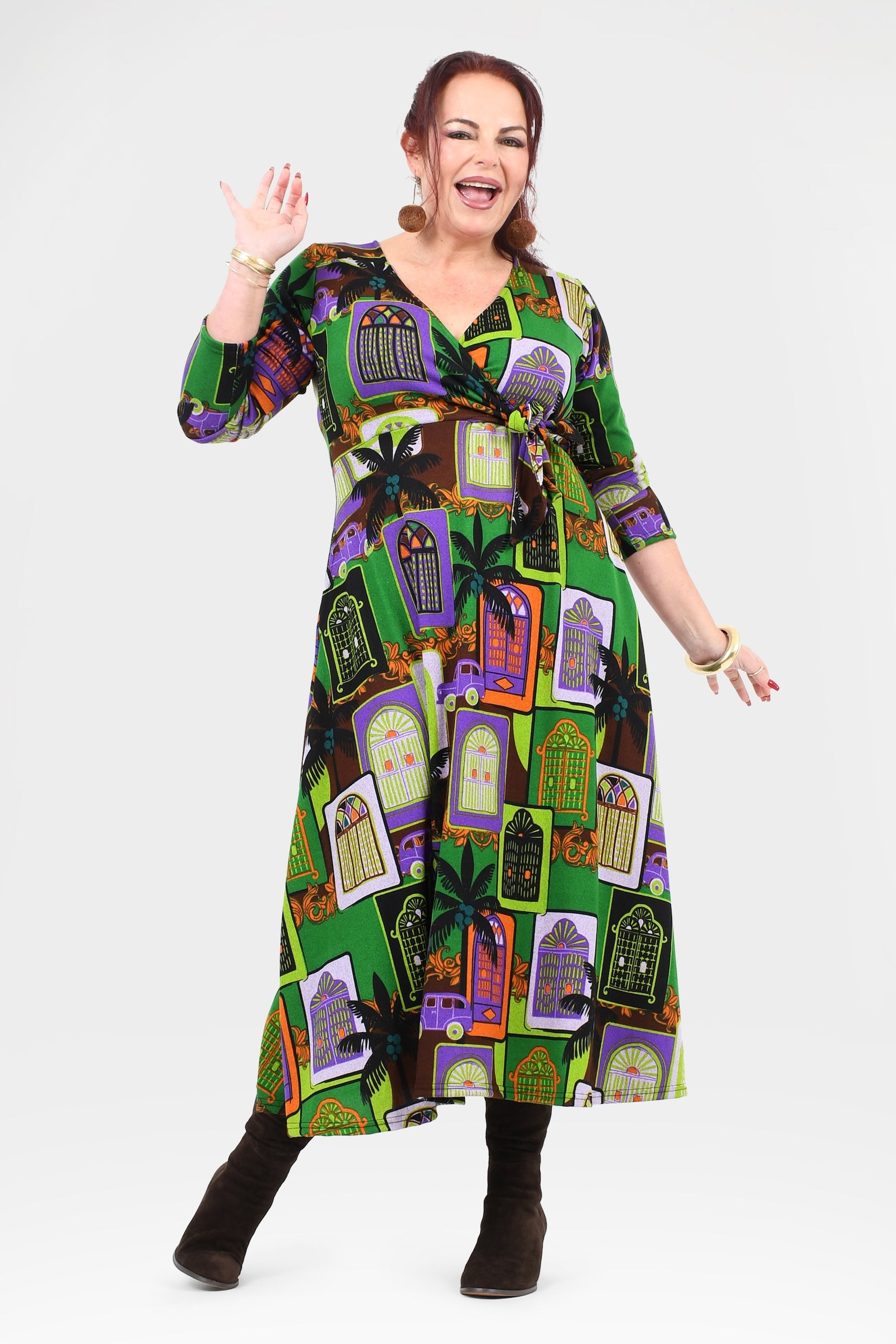 Woman wearing a colorful dress with a pattern of haunted houses on a white background